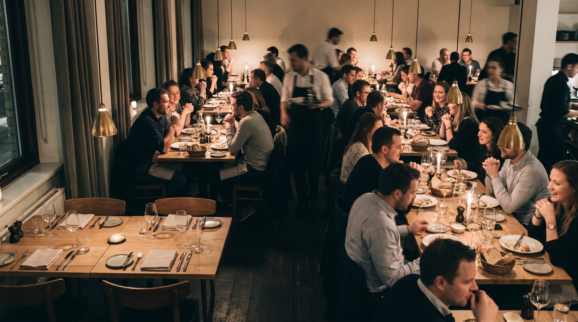 A full restaurant with two empty set tables